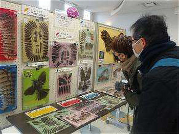 管理事務所ホールでの展示物を興味深くみる参加者たち