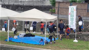 「自然観察会」ののぼりが立つ受付テント周辺に集まる参加者たち