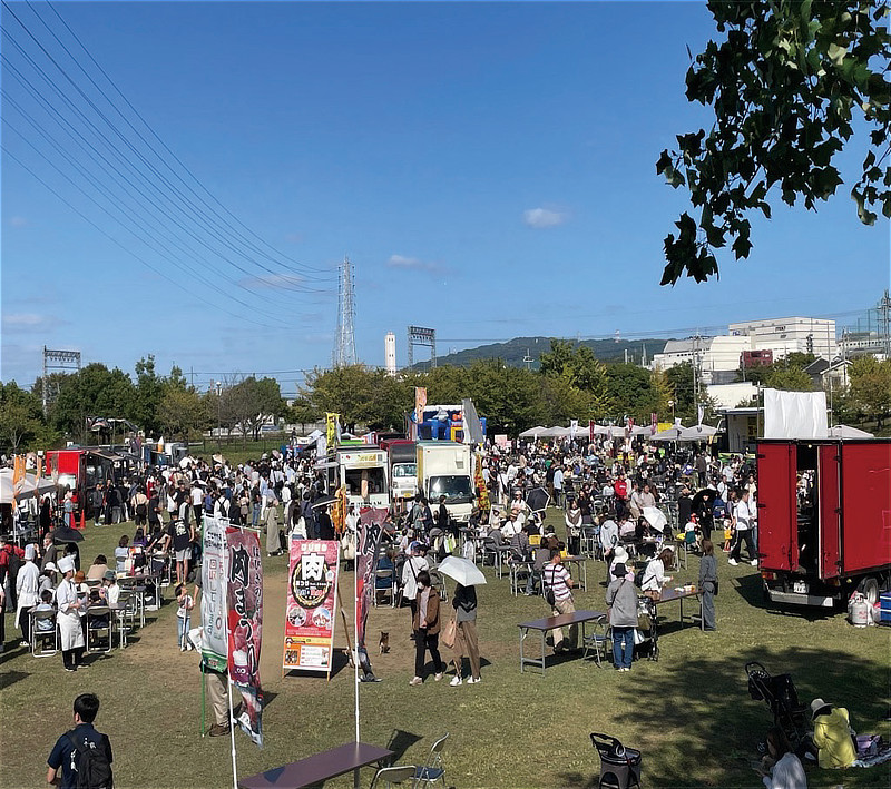はびきの肉まつり feat.日本の食まつりの会場風景。青空のもと広場にキッチンカーや屋台が並び賑わう様子
