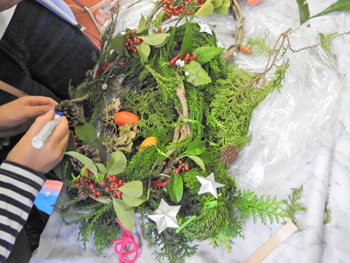 秋の野草の材料を飾り付けてオリジナルリースを作っています