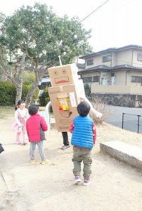 ダンボールのロボットと遊ぶ子供達