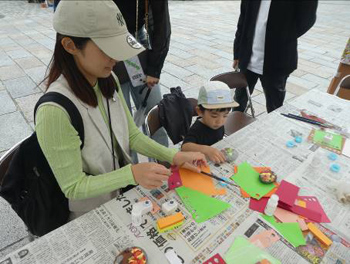 親子で色々な色用紙を葉っぱに型抜きしています。