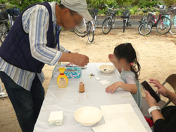 スタッフから教えてもらう子供