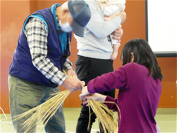 講師の方のサポートでしめ縄づくりに挑む子供