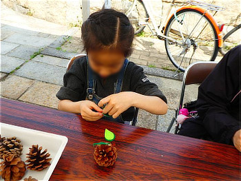 松ぼっくりにフェルトを貼り付ける参加された子供