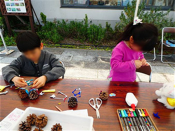 松ぼっくりにフェルトを貼り付ける参加された子供たち