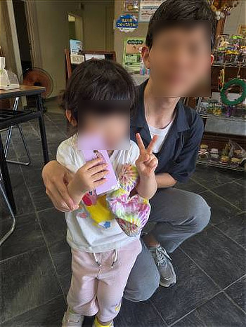完成した手作りの栞を大切そうに胸に抱え、保護者と笑顔で並ぶ女の子