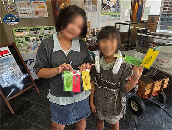 完成したカラフルな葉脈しおりを手に持ち、うれしそうに披露する子どもたちの様子