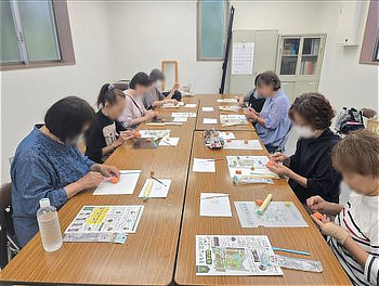 会議室の長机で軽量粘土を使ったカボチャ作りに取り組む参加者たち